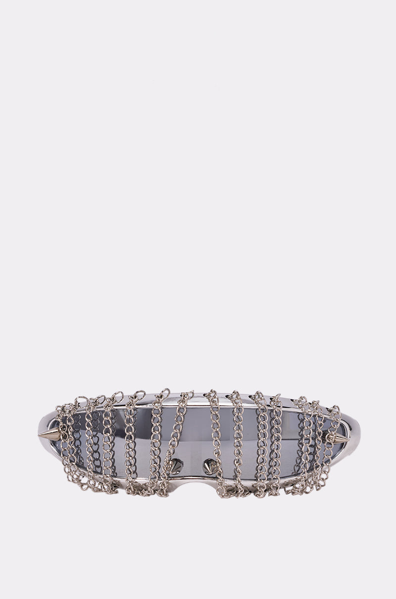 The CHAINED DOWN SUNGLASSES feature a silver shield design with multiple thin silver chains hanging vertically across the front of the lenses, showcased against a simple light background. 0