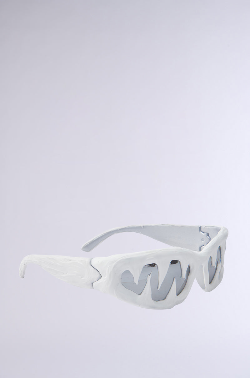 The ICED OUT SUNGLASSES feature white, sculptural frames with icicle-inspired shapes, wavy textures, and mirrored lenses. Bold and artistic, these eyewear pieces stand out against a light gray background with hand-crafted detailing.