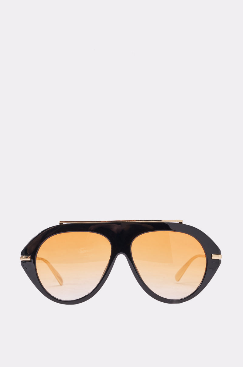 The LUXE AIR SUNGLASSES IN BLACK ORANGE feature oversized aviator frames, thick black rims, and large rounded amber-tinted lenses, creating a bold and stylish summer look against a plain white background. 0