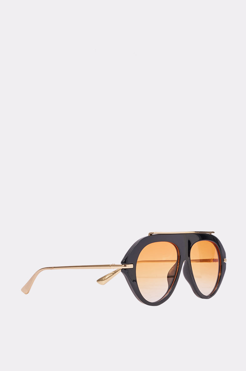 Side view of LUXE AIR SUNGLASSES IN BLACK ORANGE featuring round orange-tinted lenses, a black frame, and metallic gold arms—perfect for summer, set against a plain light gray background. 3