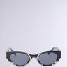 Introducing VENOM LOVE SUNGLASSES: fashion-forward black cat-eye frames with metallic snake-inspired side detailing. Featuring dark oval lenses, these bold sunglasses stand out effortlessly against a light gray background.
