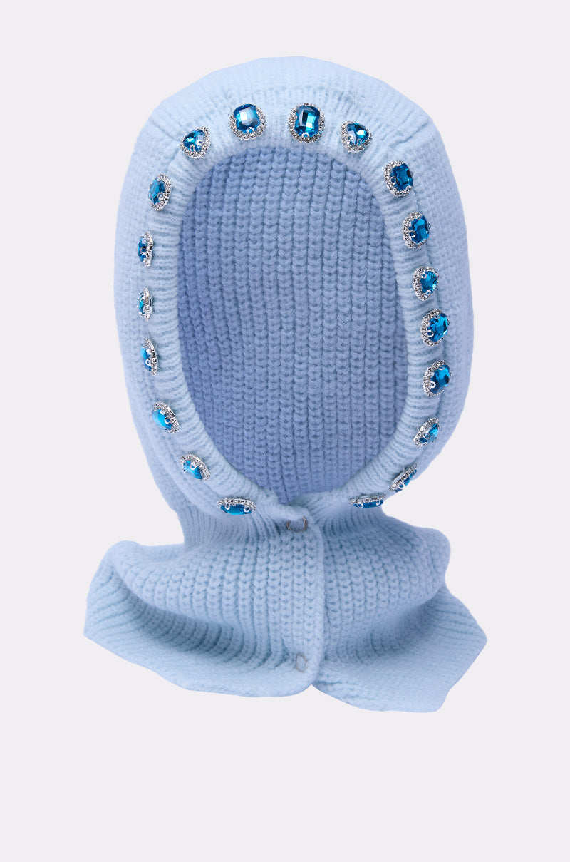 The TRU EMBELLISHED SNOOD is a light blue fisherman knit snood with a wide face opening, large blue and clear gemstones on the edge, and chin buttons, shown against a plain background. 3