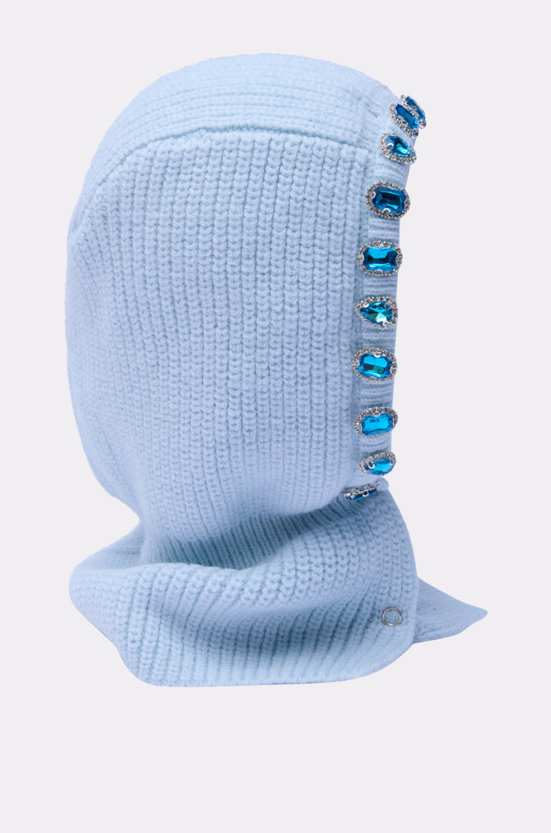 The TRU EMBELLISHED SNOOD is a light blue fisherman knit hood balaclava, featuring large rectangular rhinestone jewels along the side seam, shown against a plain light background. 4