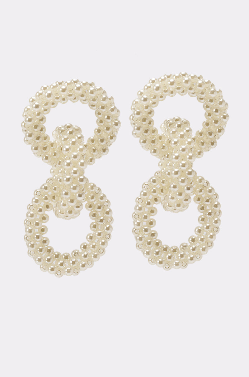The PEARL BABY DANGLE EARRING features small white pearl beads, with each earring showcasing two interlocking circles placed vertically, displayed against a plain white background. 2