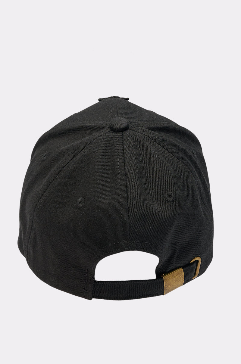 The EMBELLISH ME BASEBALL HAT is a black cap shown from the back, with an adjustable brass-buckle strap and stitched eyelets. A rhinestone cross adds subtle sparkle to its classic style. 4