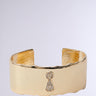 Introducing the "Key to My Heart Cuff," a chunky statement bracelet with a wide band and rhinestone-adorned keyhole design. Its polished finish beautifully catches the light against a neutral backdrop.