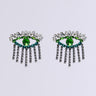 Close-up image of the EYE SEE YOU EARRING pair, showcasing a central green gemstone. They are elegantly framed by clear crystals and green accents, featuring rhinestone link fringes that mimic eyelashes. Set against a plain white background, these earrings are undeniably captivating.