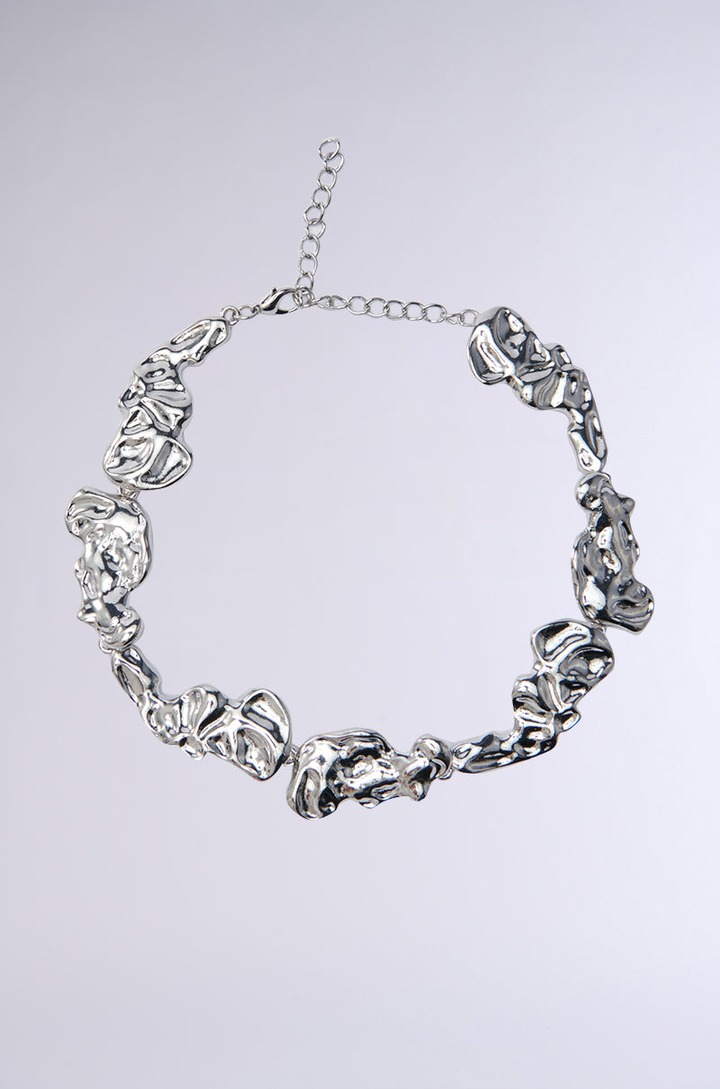 The ORGANIC VIBES CHOKER NECKLACE features chunky, irregular geometric links in faux silver and an adjustable clasp, displayed on a light gray background.