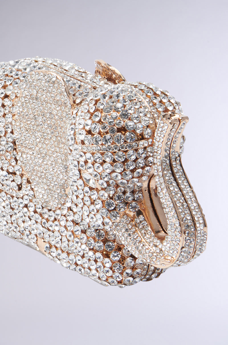 A close-up of the BLING ELEPHANT CLUTCH showcases its sparkling rhinestones and gold accents. The textured details of this rhinestone bag emphasize the elephant's ears, trunk, and tusks with dazzling precision.