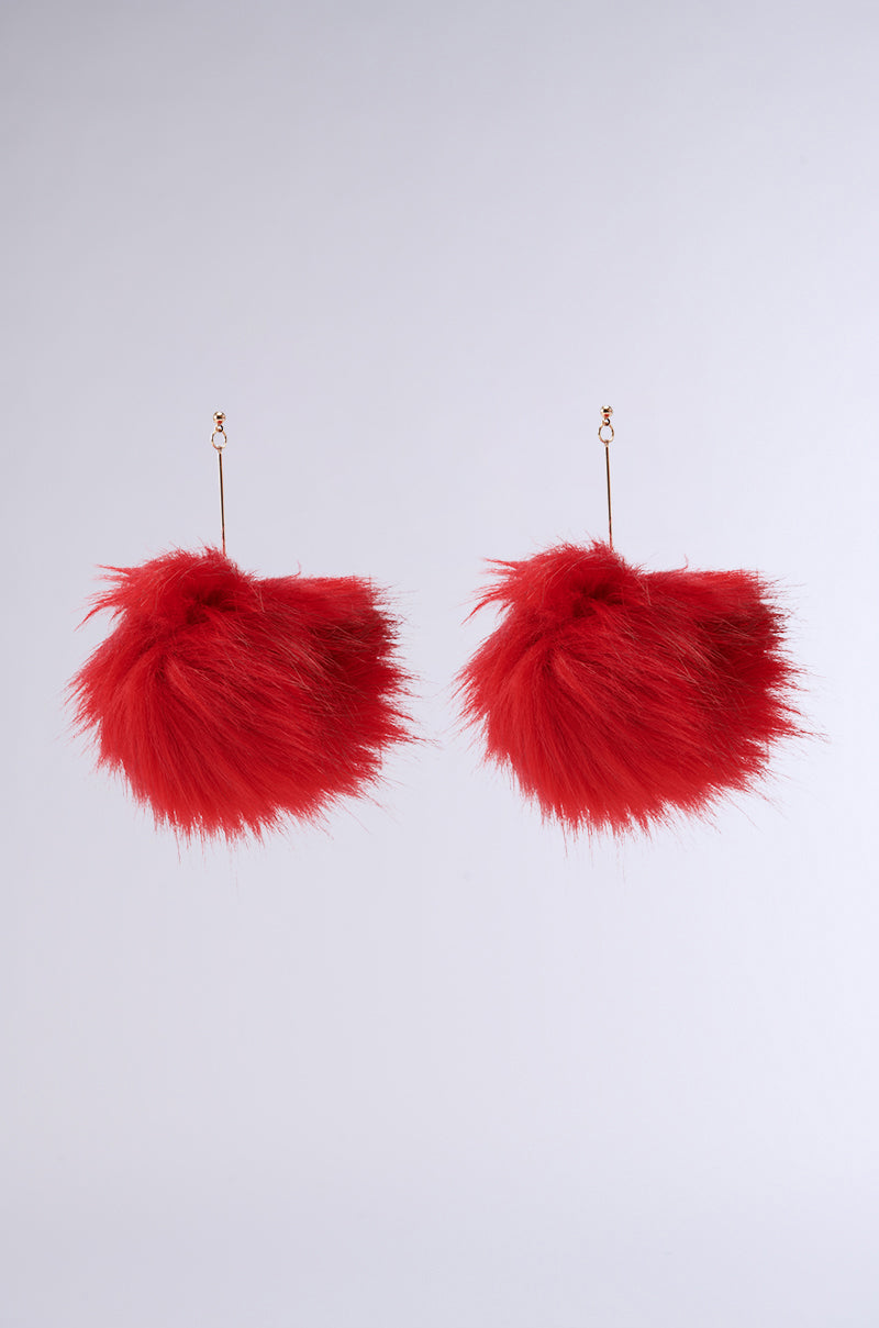 Two oversized MAMI FUR EARRINGS with faux metallic gold hooks are hanging against a plain white background. The red fuzzy balls have a fluffy, textured appearance. 1