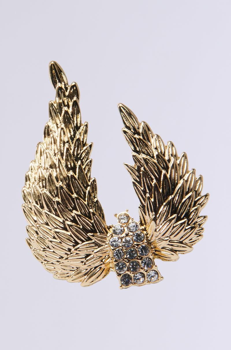 Angelic Cocktail Ring featuring an angel wing silhouette with intricately detailed feathers and a row of rhinestone embellishments at the base. The design angles upward against a plain background.