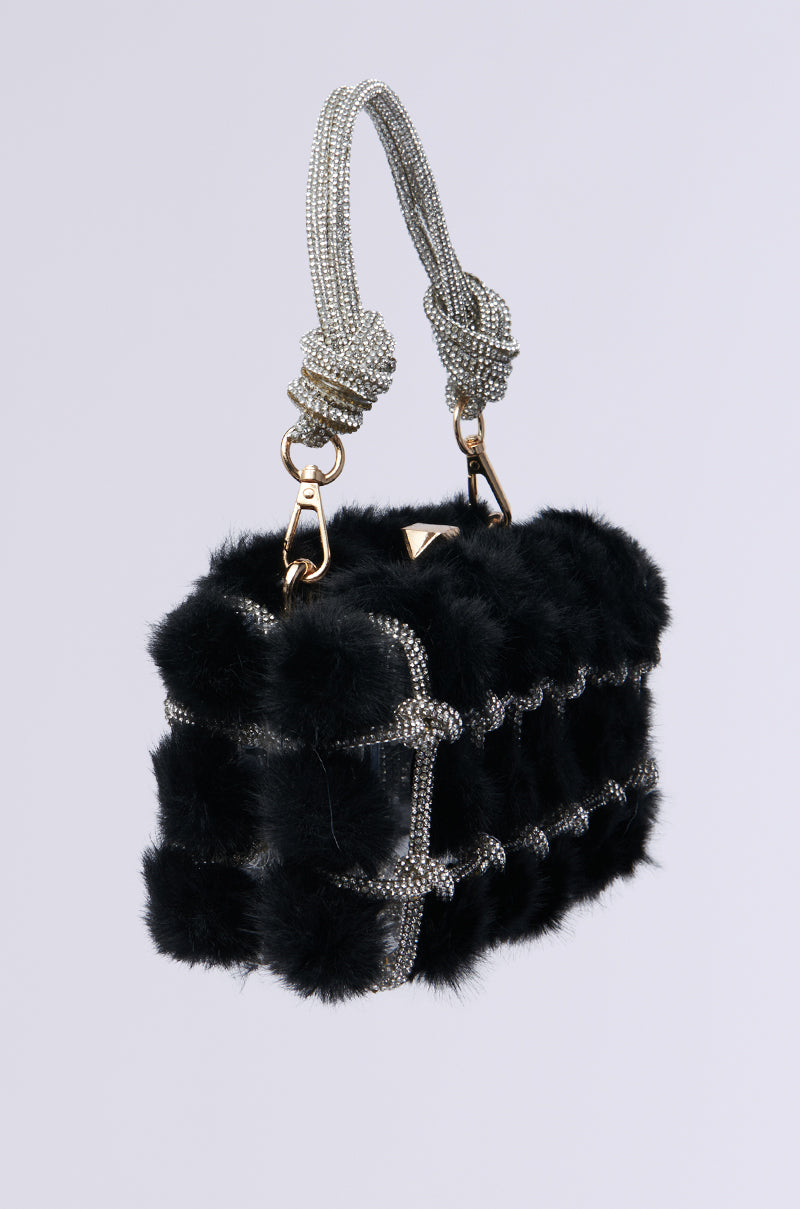 The IT GIRL FAUX FUR CLUTCH showcases a rhinestone-adorned handle and silver beaded details, accented with gold hardware. Its chic boxy design is enhanced by a metallic snap-top closure for an extra touch of elegance.