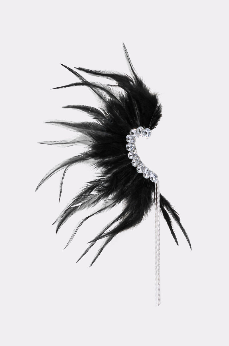 The GLAM BIRD BLACK FEATHER EAR CUFF IN BLACK SILVER features black feathers, silver rhinestones, and a long silver chain, making a bold statement accessory against a light background. 3