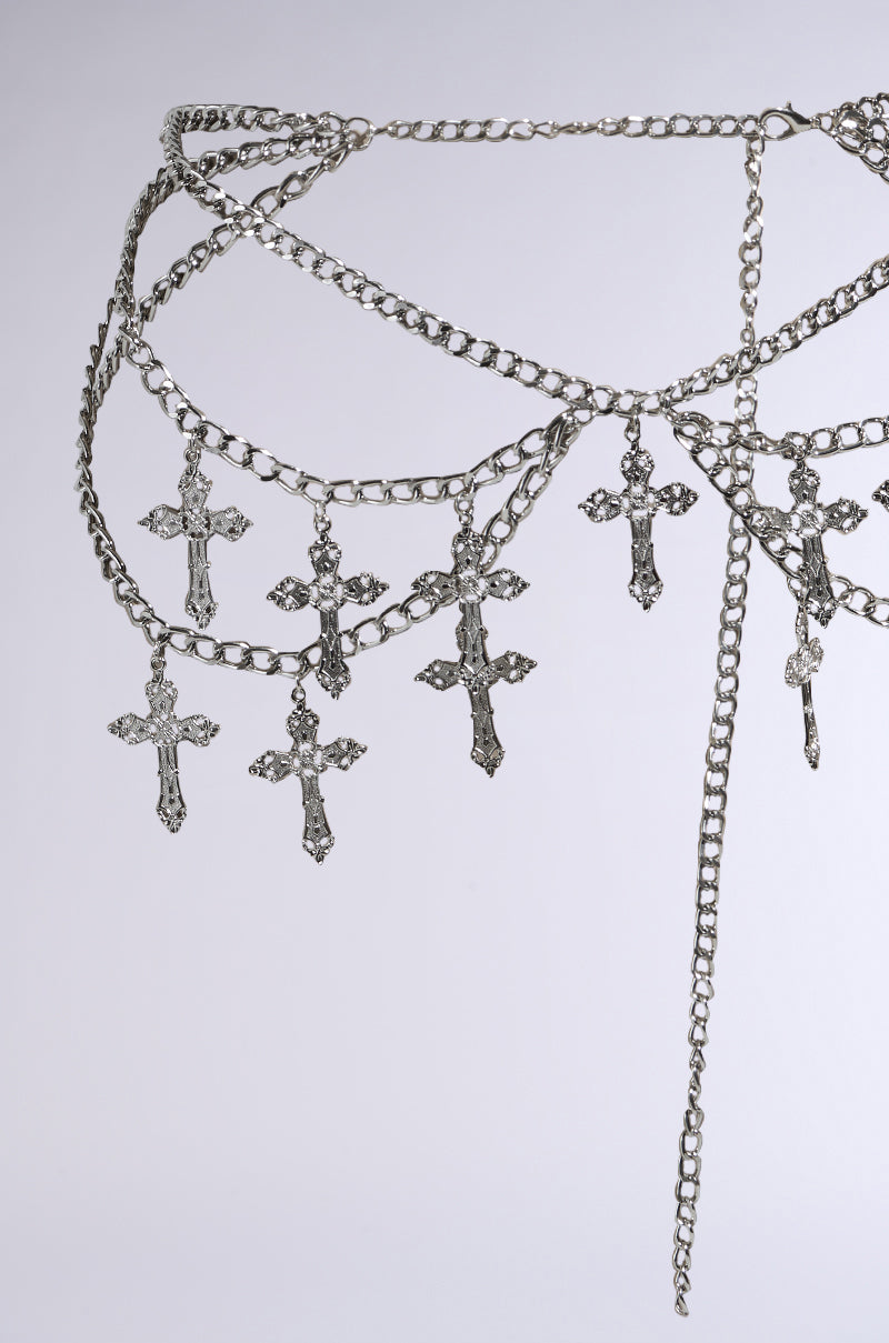 CROSS MY HEART CHAIN BELT features a faux silver design with multiple dangling cross charms against a plain background. Its intricate chain links overlap to create a layered, decorative look. 7
