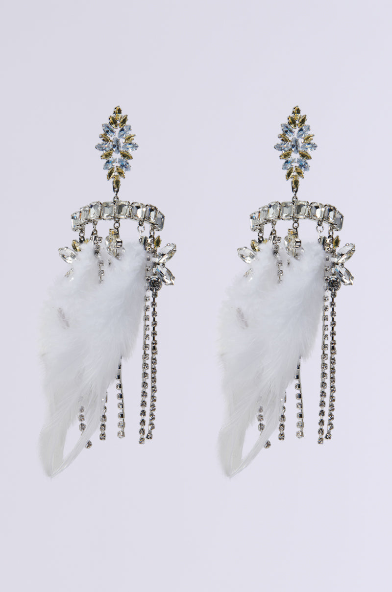 Exquisite MIAMI MAMI STATEMENT EARRING showcasing a floral top adorned with crystal embellishments, complemented by delicate white feathers and cascading chains adorned with tiny crystals. These earrings create a striking appearance when set against a plain background.