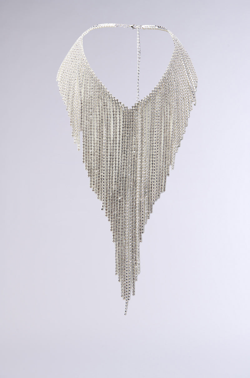 The TOP TIER STATEMENT NECKLACE showcases a dramatic silver design with layers of cascading chains and rhinestone details, forming a striking V-shaped fringe. The densely packed chains create an impactful flowing effect against any neutral backdrop, and it secures effortlessly with an adjustable lobster clasp closure.