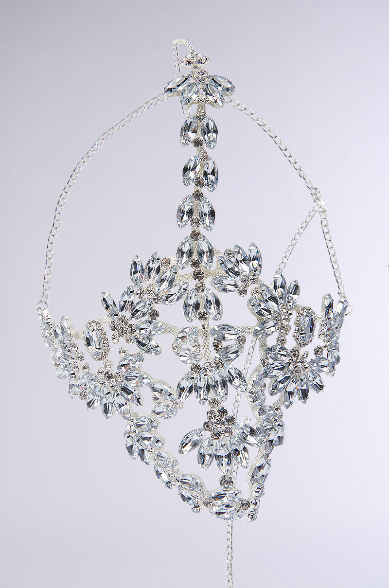 Introducing the TAKE MY PIC STATEMENT HEADPIECE: a stunning silver masquerade mask embellished with intricate patterns and teardrop gemstones set against a plain white background. This exquisite mask is adorned with delicate chains, an adjustable lobster clasp, and elegant leaf-like designs. 2