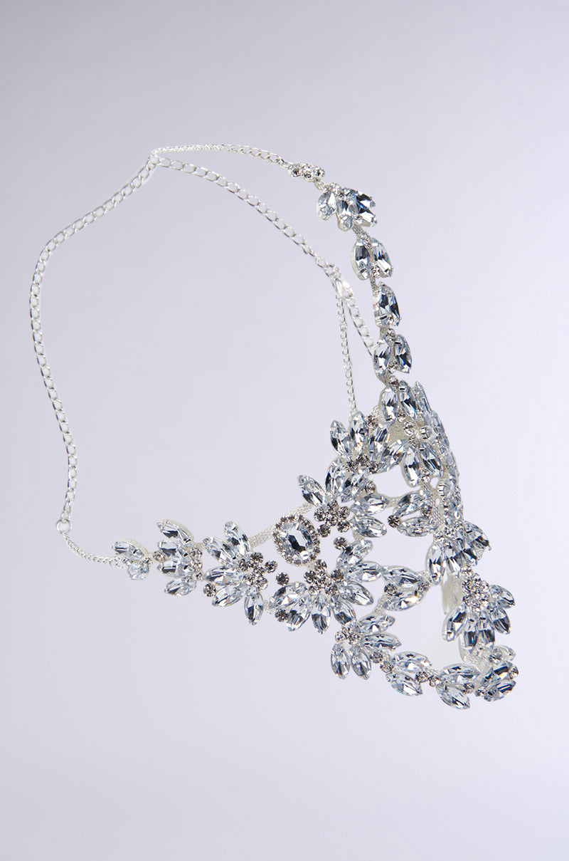 Introducing the TAKE MY PIC STATEMENT HEADPIECE—a silver headpiece adorned with an intricate floral design and large, sparkling teardrop gemstone embellishments arranged in various shapes. It features an adjustable lobster clasp for a perfect fit and is showcased against a plain light gray backdrop. 3