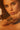 A woman with light eyes and wavy brown hair poses closely, her chin resting on her arm. She wears the GOLDEN GODDESS CUFF, a bold metallic statement piece, paired with soft natural makeup and defined lashes.