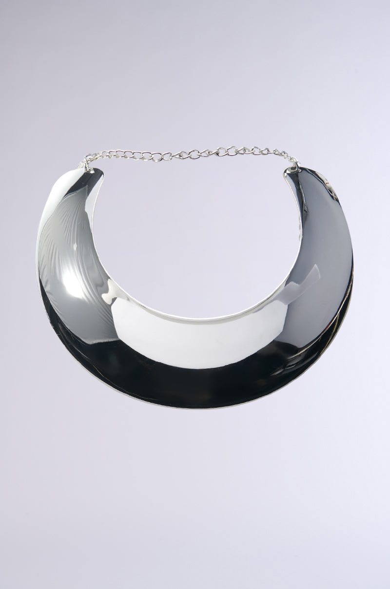 The THIS MY SHI CHOKER NECKLACE, featuring a shiny, thick crescent shape and a delicate chain, is displayed against a light gray background, making it the perfect statement accessory.