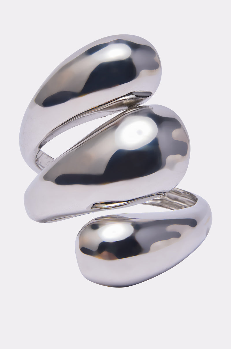 A sleek, modern LOVER BRACELET CUFF featuring three smooth, overlapping pebble-inspired bands in a wave design, displayed against a light gray background. 1