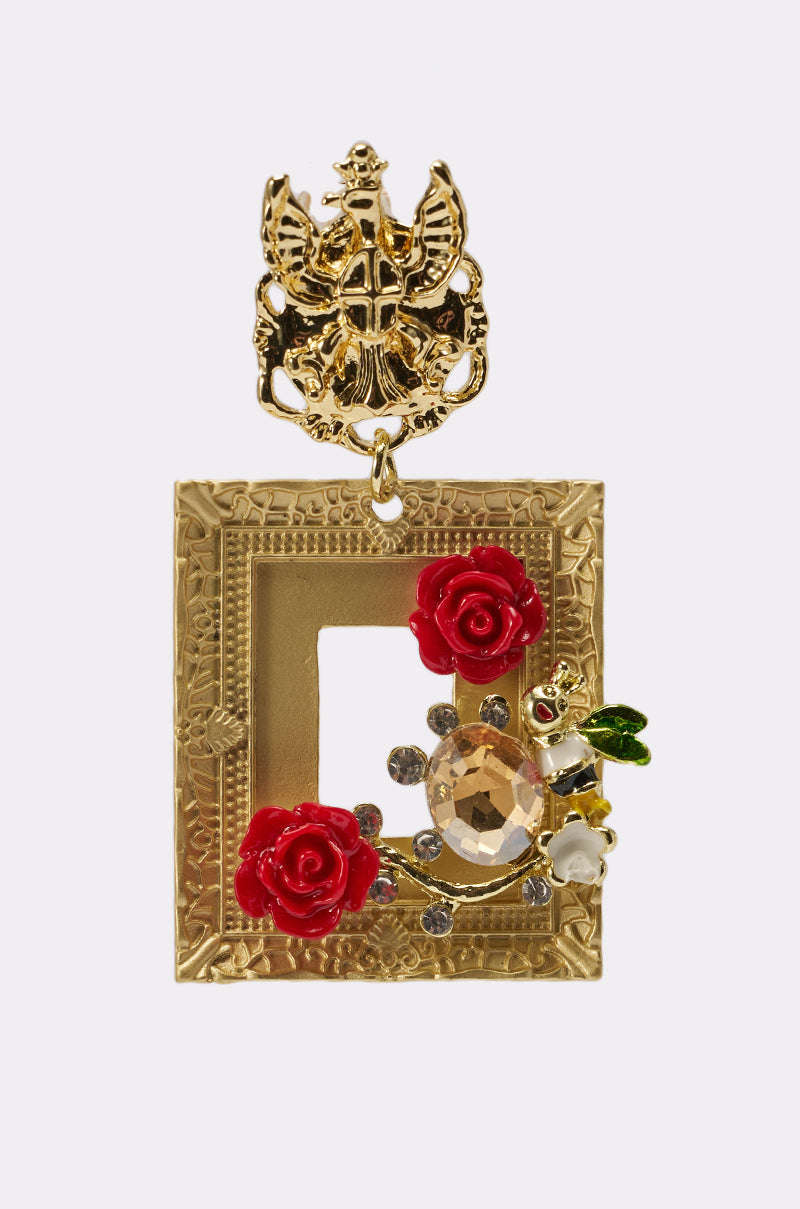 The PICTURE PERFECT EARRING features a picture-frame design adorned with red and white flowers, a jeweled bee, clear crystals, and a detailed gold crest at the top. 3