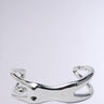 The I AM EVERYTHING BRACELET by AKIRA Label features a polished, abstract twisted design in faux silver metallic against a plain gray backdrop.