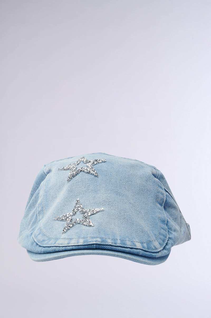 The MARDIE GURL HAT features a light blue denim scally cap with two rhinestone stars on top, contrasting subtly with its plain light gray background. 1