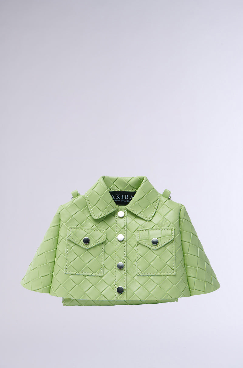The HOLD MY TOP PURSE is a small, green quilted handbag made from vegan leather, resembling a jacket. It features button, collar, and two flap pocket details with chain link straps, making it a unique and stylish statement piece against any plain background. 0