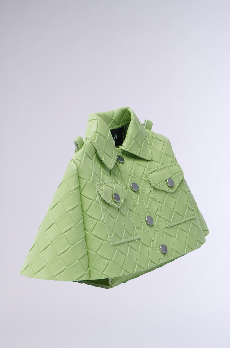 The HOLD MY TOP PURSE is a green handbag resembling a jacket, crafted from vegan leather with an intricate quilted pattern and decorative buttons. It features a magnetic front flap closure and is beautifully displayed against a plain gray background. 2
