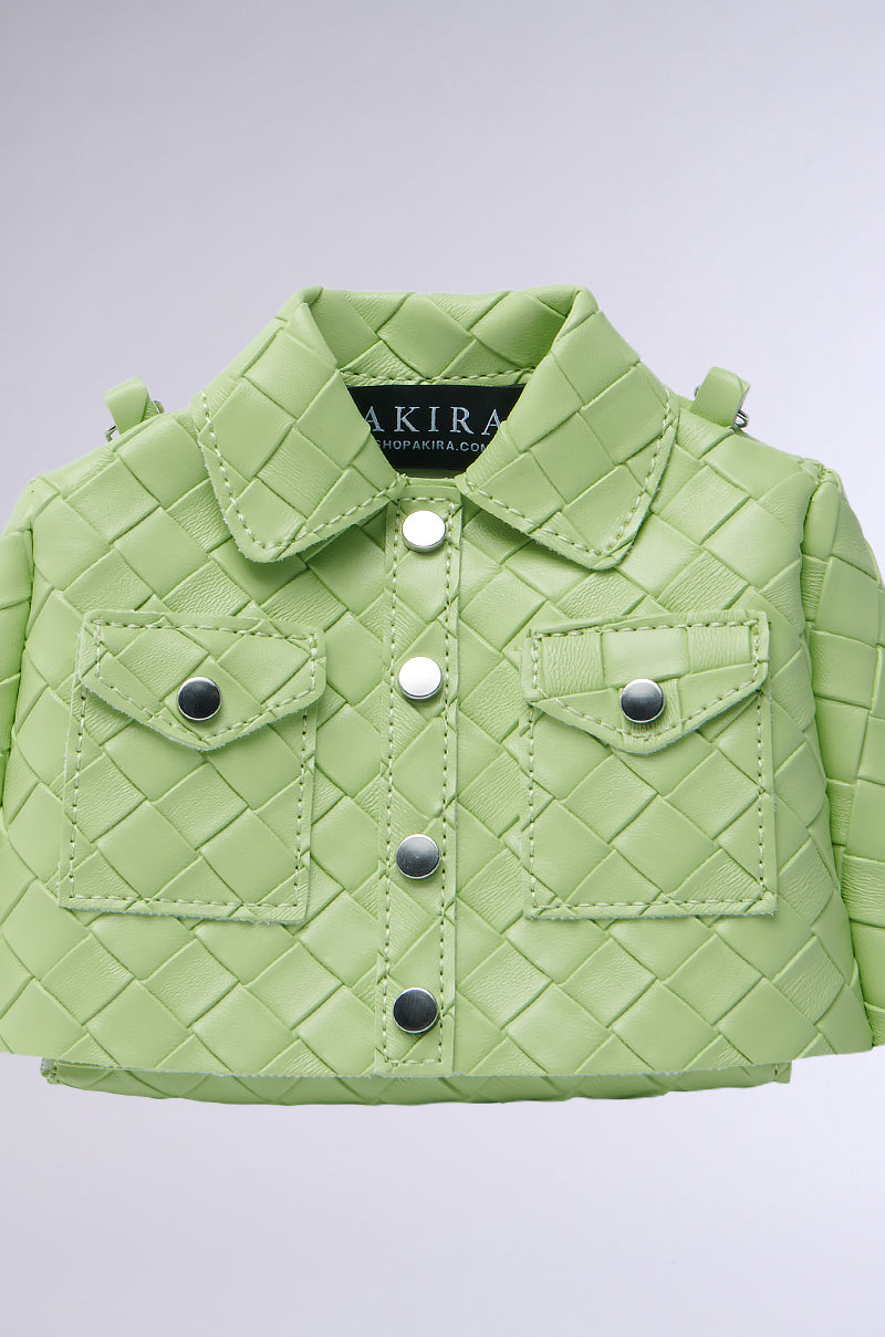 The HOLD MY TOP PURSE is a distinctive handbag crafted from vegan leather, styled to look like a green quilted jacket with button details, two front pockets, and a collar. Inside, it features an "AKIRA" tag. Its textured pattern and magnetic front flap closure make it an eye-catching statement piece. 3