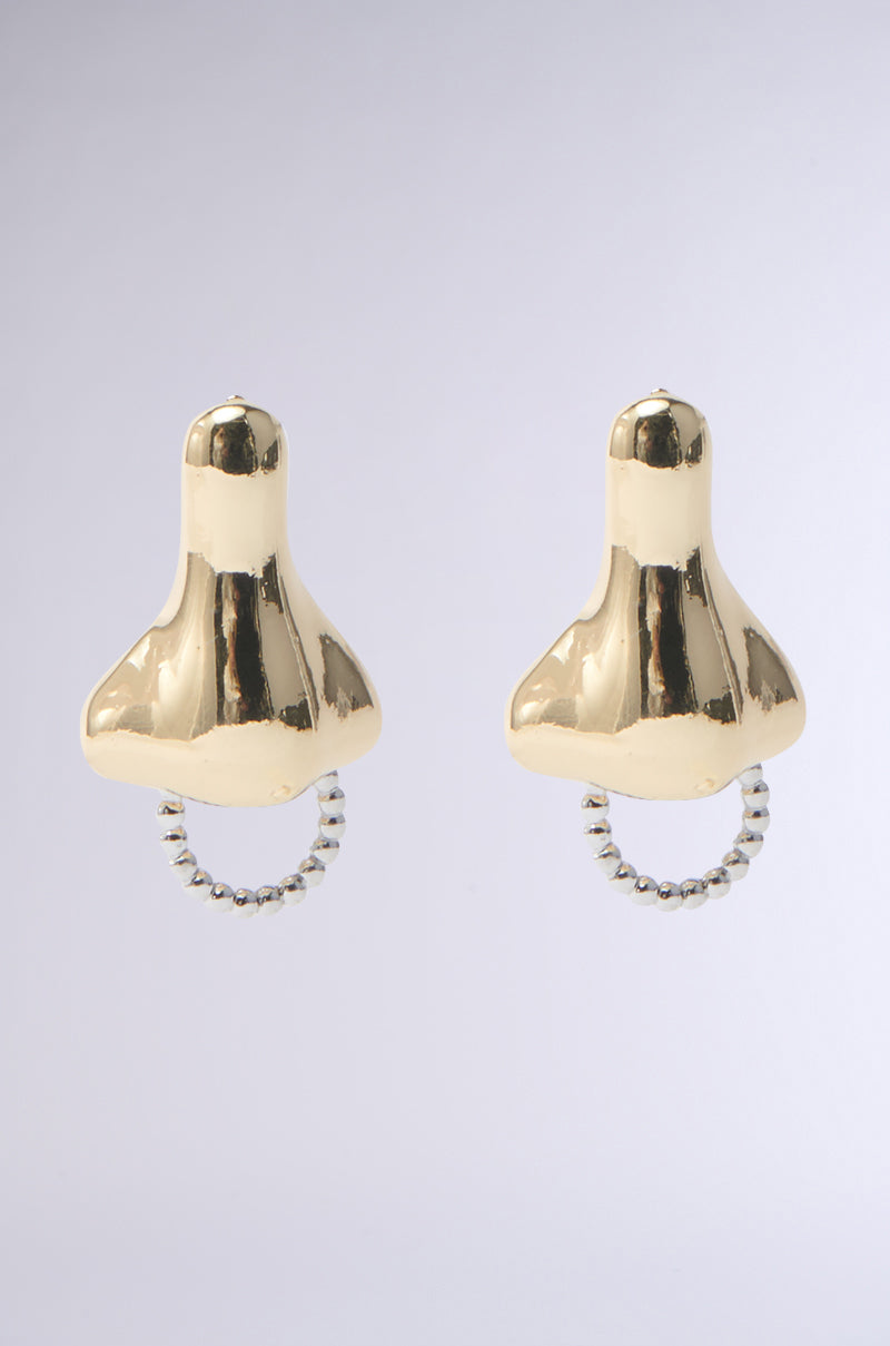 The NEVER SAY GOLD NOSE EARRING, featuring gold nose-shaped pendants and a silver hoop piercing at the bottom, shines against a gray background.
