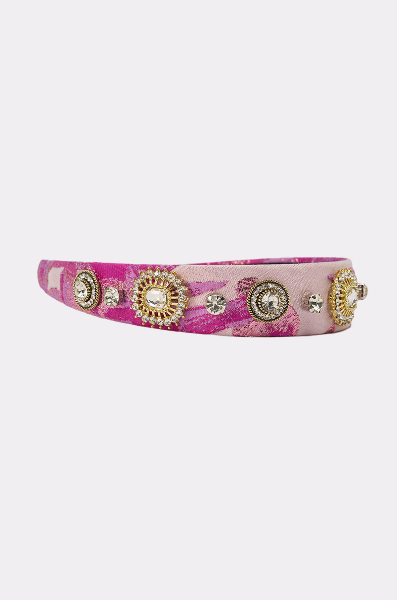 The GIRLS GIRL EMBELLISHED HEADBAND features a pink, textured design adorned with gold and silver gems and round embellishments. Shown against a plain white background. 3