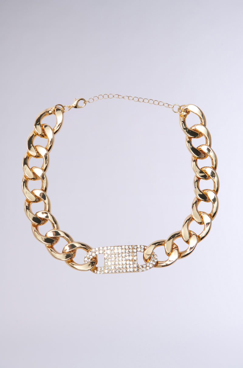 The ELEGANCE IS KEY CHOKER, featuring thick interlocking links and a rectangular section with sparkling rhinestones, is displayed on a plain gray background.