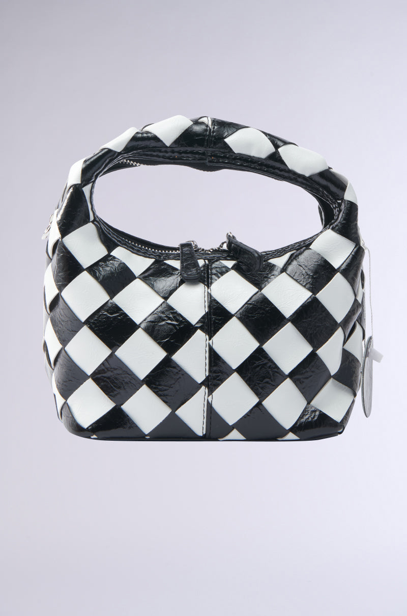 The SPLIT DECISION PU PURSE is a black and white checkered handbag featuring a braided handle and zip closure, shown against a plain light gray background.