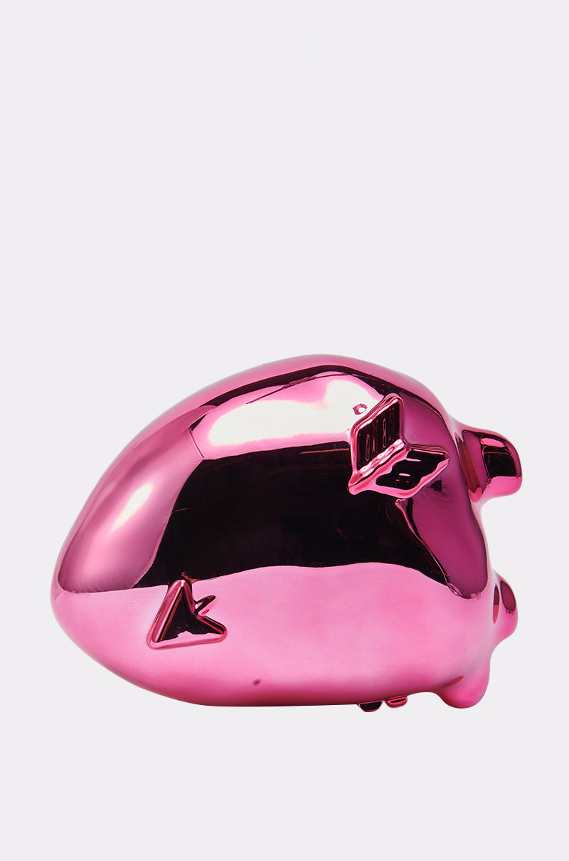 The STOLE MY HEART CLUTCH is a shiny, metallic pink statement purse with a smooth, reflective surface, resembling a whimsical piggy bank and displayed against a plain white background.