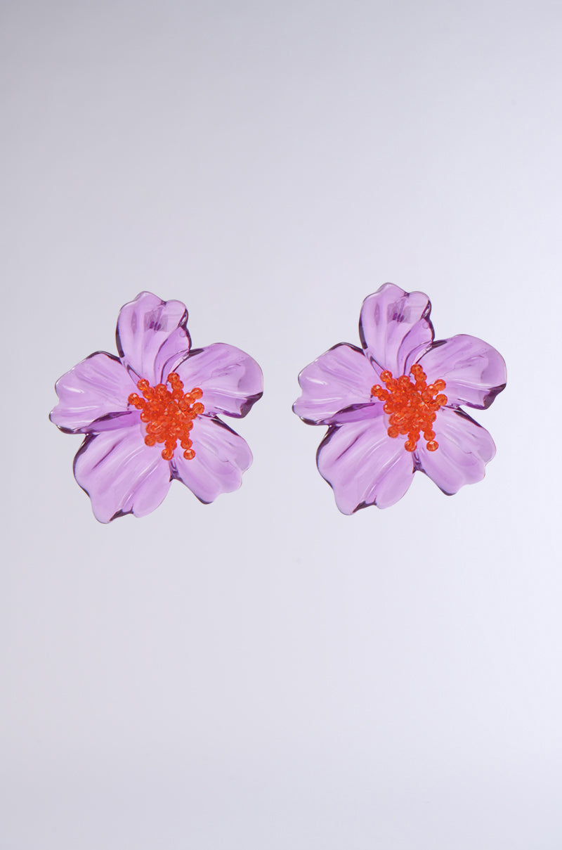 Two MAKE YOU JEALOUS EARRING pieces featuring light purple petals and bright orange centers evoke a delicate floral silhouette, displayed against a plain light gray background.