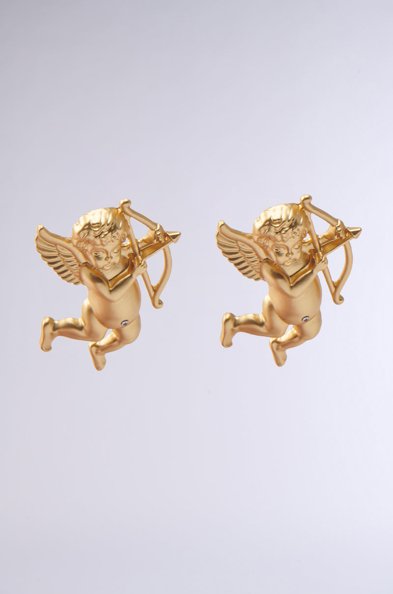 The WATCH ME FLY EARRING features two cherub-shaped designs in faux gold metallic against a plain background. Each cupid ornament showcases wings, bows, arrows, and a focused expression, exuding timeless elegance.
