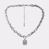 The SHES EXPENSIVE SILVER NECKLACE features mixed links, an adjustable clasp, and a rectangular pendant with a clear gem framed by small stones. Its chunky curb chain stands out against a plain white background.