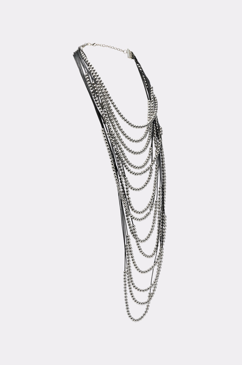 The WANNA LOVE NECKLACE is a striking statement piece with layered silver chains and black straps cascading elegantly—a bold, contemporary jewelry design. 3