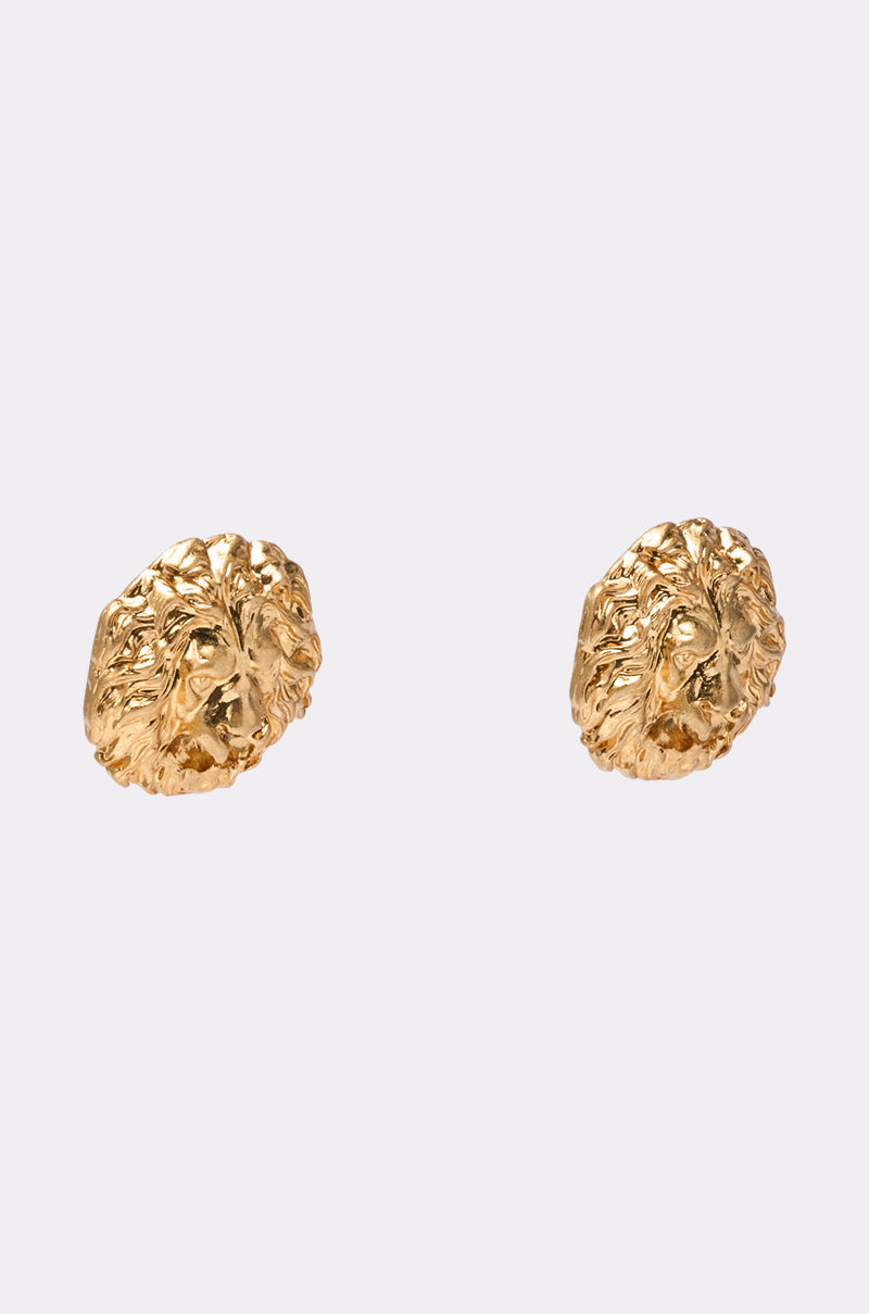 The ROAR EARRING features bold, gold metallic lion head designs. These striking statement earrings are displayed against a simple light background. 3