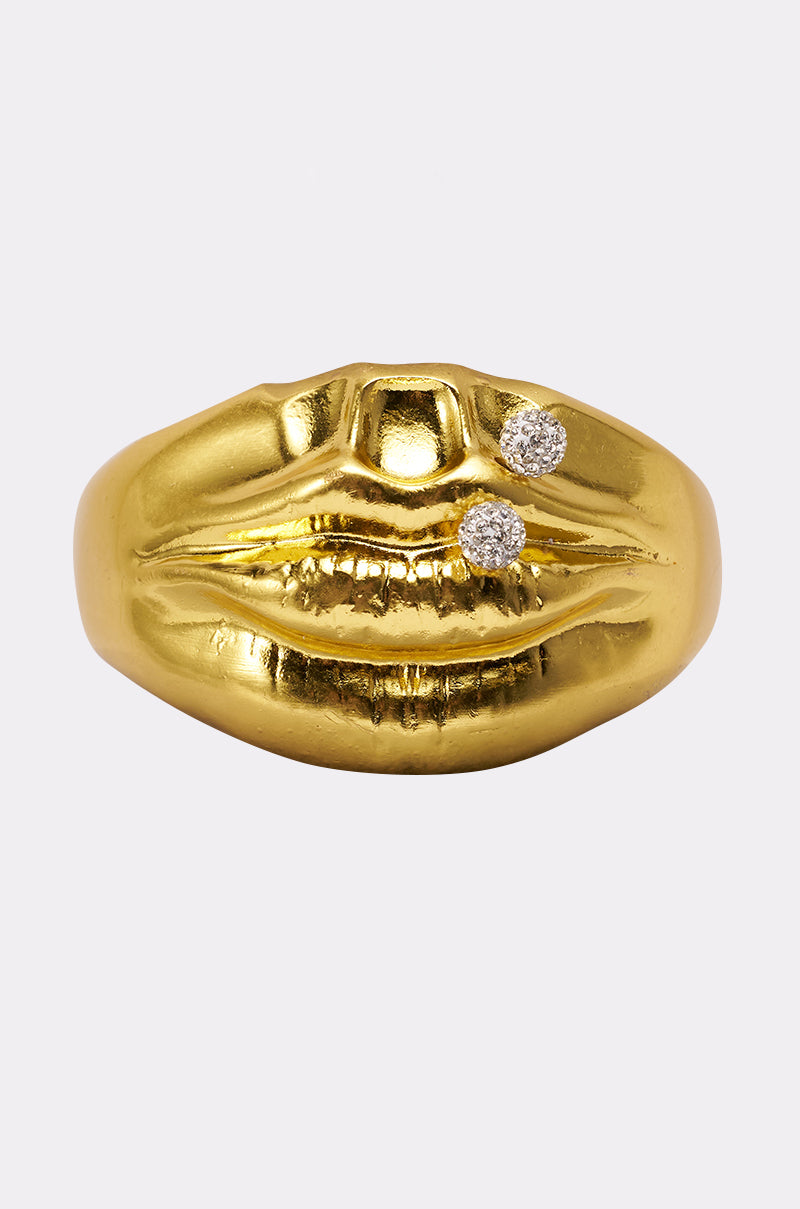 The RAWR BRACELET is shaped like lips and features two small round diamonds set to resemble crystal piercings, displayed against a plain white background. 0