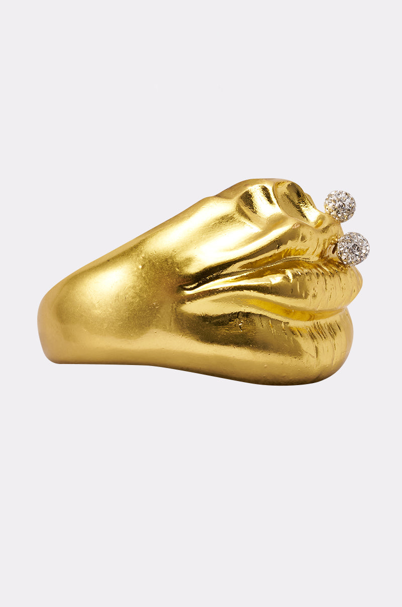 The RAWR BRACELET is shaped like lips, featuring two small round crystals above the upper lip resembling a piercing, shown on a plain white background. 2