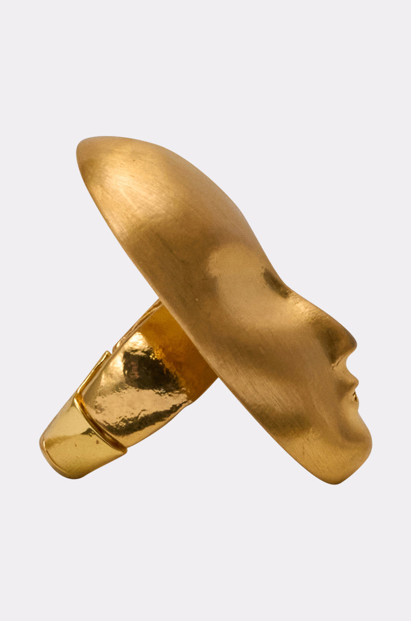 The OUTTA THIS WORLD RING is a modern, artistic statement piece featuring a gold metallic band seamlessly connecting to an abstract 3D face in profile, with smooth, polished details. 2