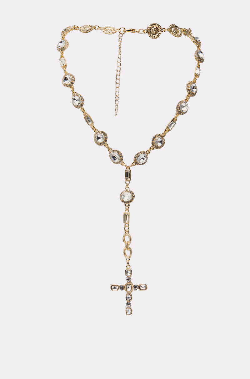 The TOTALLY CROSSED NECKLACE IN GOLD features a jeweled cross pendant with clear crystals, an ornate chain, adjustable clasp, and intricate decorative detailing throughout. 2