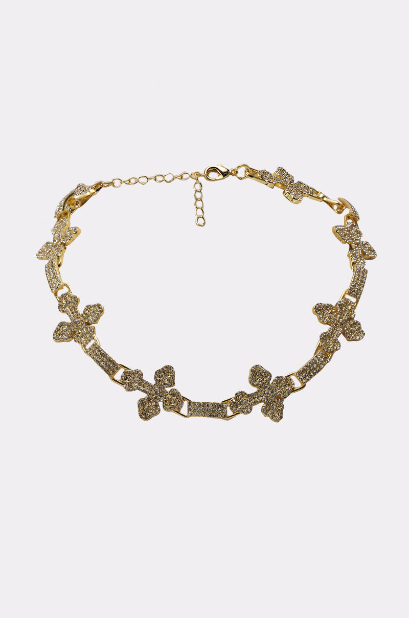 The CROSS MY HEART NECKLACE is a statement piece with sparkling butterfly-shaped links, each covered in rhinestones, shown against a plain white background. 2