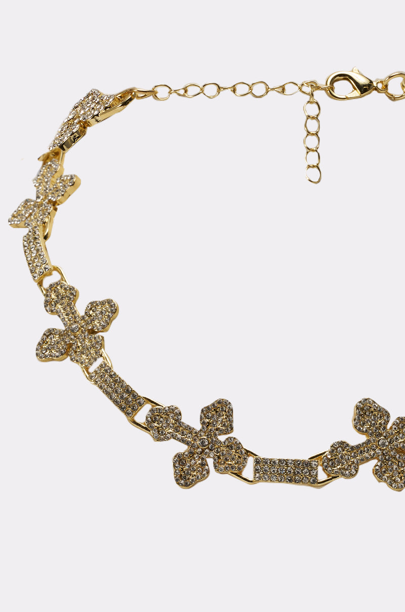 The CROSS MY HEART NECKLACE features sparkling, crystal-studded floral motifs and an adjustable chain clasp, displayed on a plain white background. 3