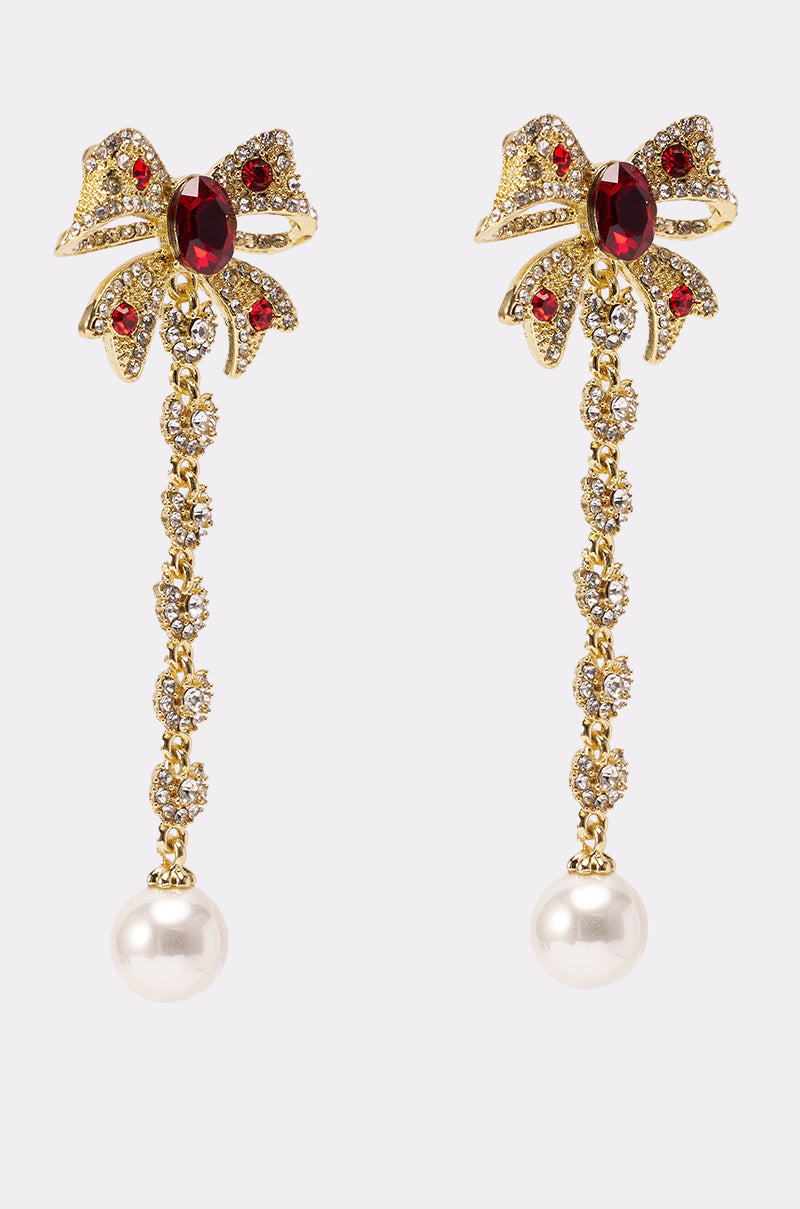 TIE WITH A BOW EARRING: Gold-tone bow earrings with red gemstones, featuring dangling crystal chains ending in large white pearl drops. 2