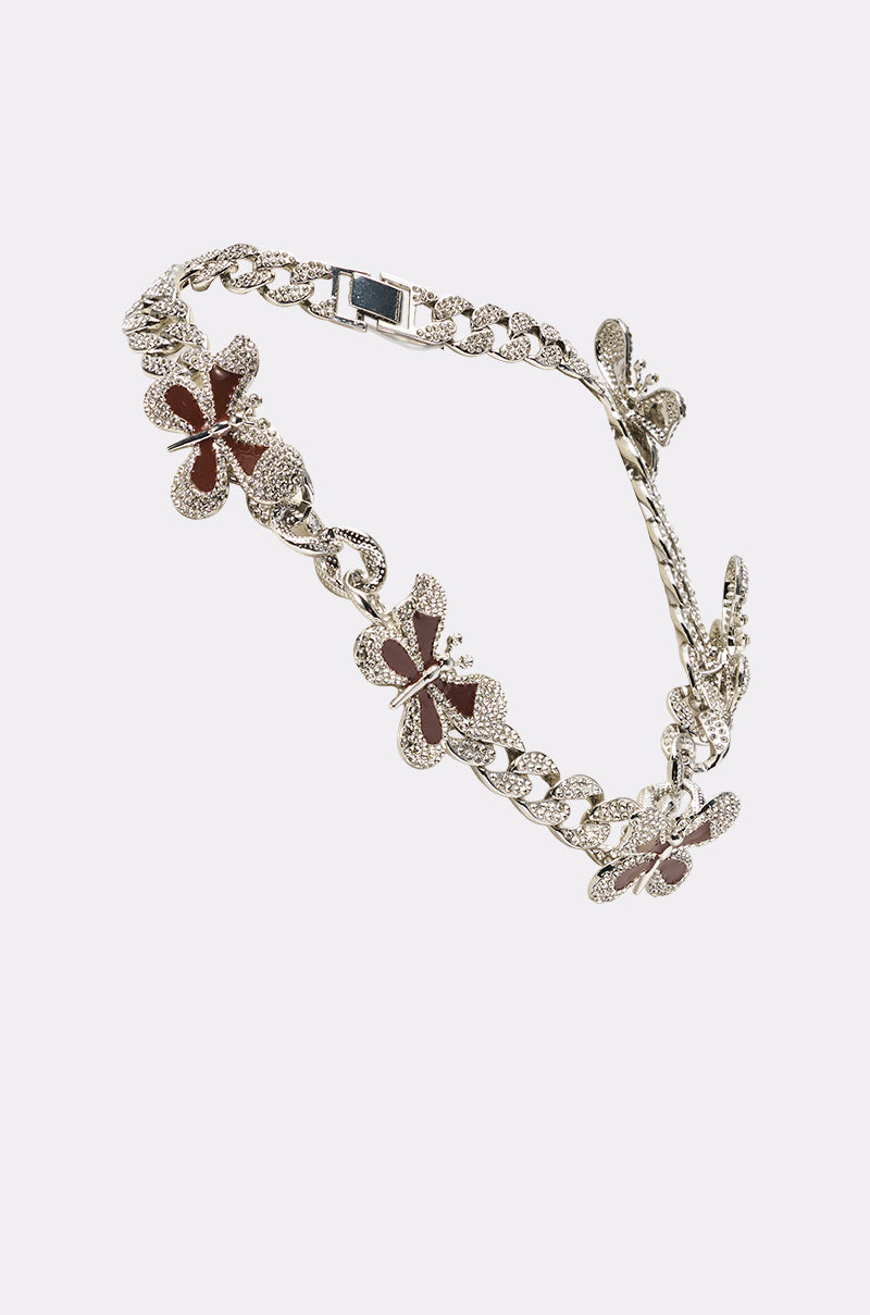 The LUXE BUTTERFLY NECKLACE is a silver-toned chain adorned with large butterfly charms featuring textured details and dark red enamel accents, displayed on a light background. 4