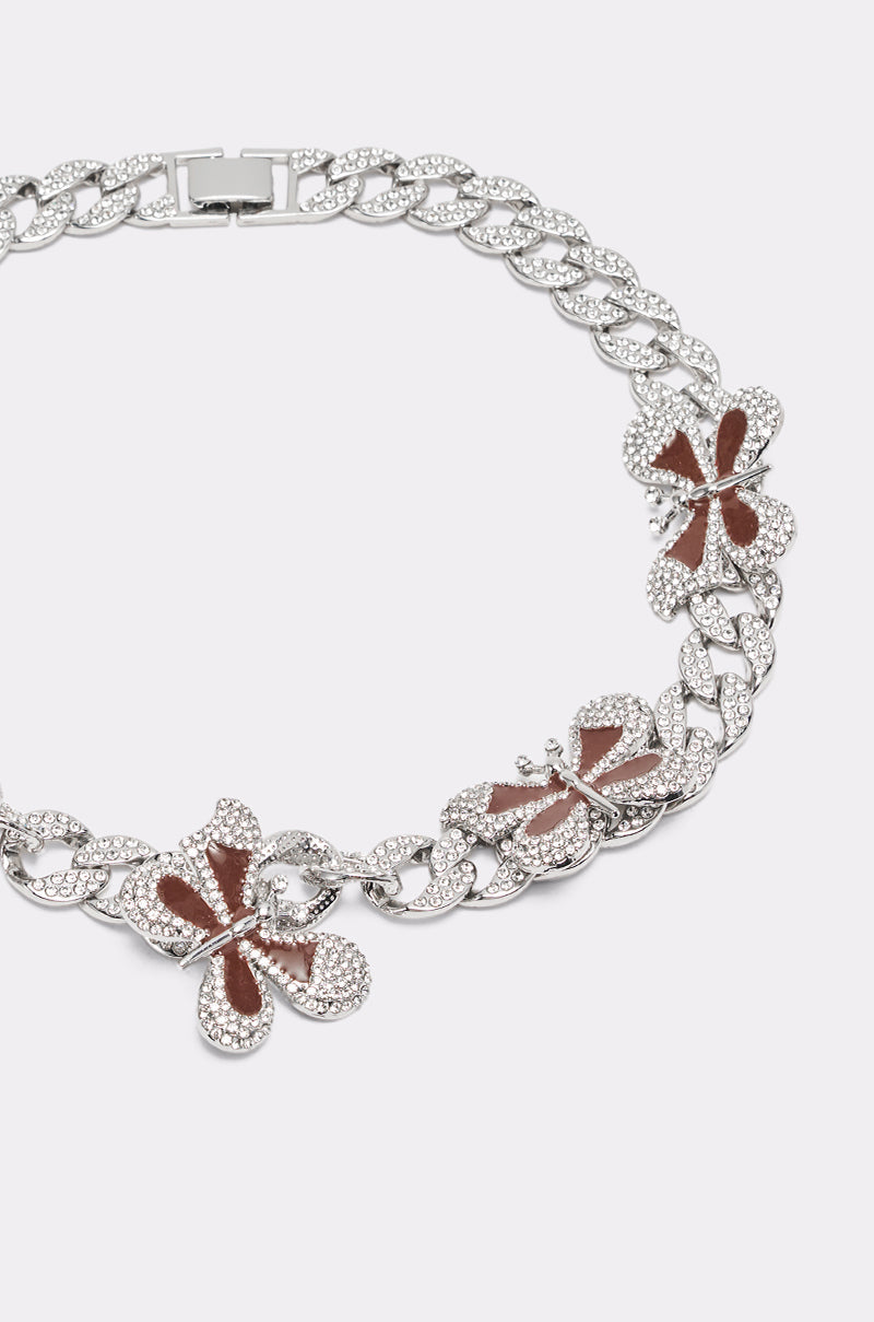 The LUXE BUTTERFLY NECKLACE features a silver chain with three butterfly pendants, each detailed with brown enamel and sparkling stone accents. 5